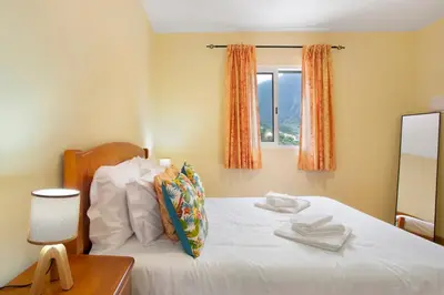 a bedroom with a bed with white towels on it at São Vicente House in São Vicente