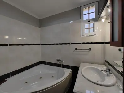 a white bathroom with a tub and a sink at Casa Rosa - Vereda da Ilha in Santana