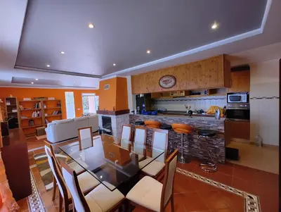 a kitchen with a glass table and chairs in it at Casa Rosa - Vereda da Ilha in Santana