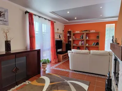 a living room with a white couch and a fireplace at Casa Rosa - Vereda da Ilha in Santana