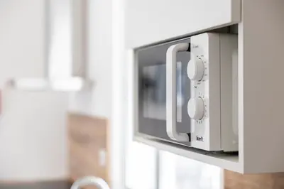 a microwave oven is attached to a wall at Apartamentos Progresso 1º Esq in Funchal
