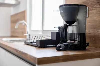a black coffee maker sitting on a kitchen counter at Apartamentos Progresso 1º Esq in Funchal