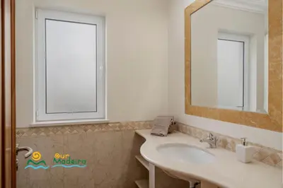 a bathroom with a sink and a mirror at OurMadeira - Palheiro Ocean in Funchal