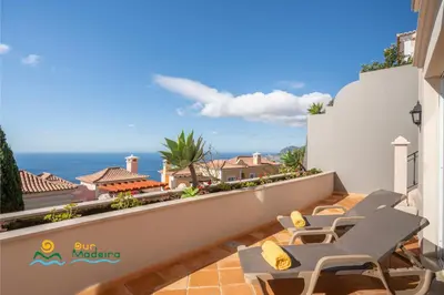 a balcony with chairs and a view of the ocean at OurMadeira - Palheiro Ocean in Funchal