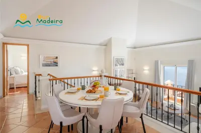 a dining room with a table and chairs at OurMadeira - Palheiro Ocean in Funchal