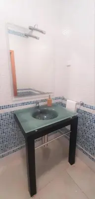 a bathroom with a green sink and a mirror at Apartamento Buganvilia in Lagos