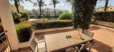 a patio with a table and chairs and a pool at Apartamento Buganvilia in Lagos