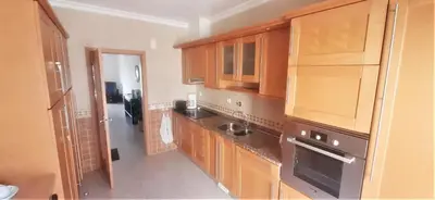 a kitchen with wooden cabinets and a sink at Apartamento Buganvilia in Lagos