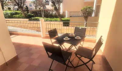 a table and chairs on a patio with a balcony at Apartamento Buganvilia in Lagos