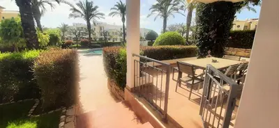a patio with a table and chairs and palm trees at Apartamento Buganvilia in Lagos