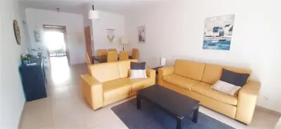 a living room with two yellow couches and a table at Apartamento Buganvilia in Lagos