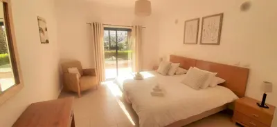 a bedroom with a bed and a chair and a window at Apartamento Buganvilia in Lagos