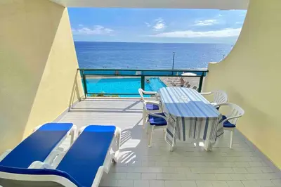 a balcony with a table and chairs and the ocean at Mar Sereno Praia Formosa in Funchal