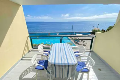 a table and chairs on a balcony with the ocean at Mar Sereno Praia Formosa in Funchal