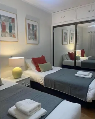 a hotel room with two beds and a mirror at Mar Sereno Praia Formosa in Funchal