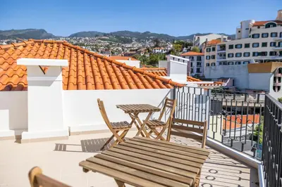 a patio with two chairs and a table on a balcony at Apartamentos Progresso 1º Dto in Funchal
