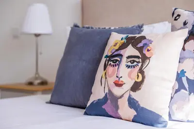 a painting of a woman on a pillow on a bed at Apartamentos Progresso 2º Esq in Funchal