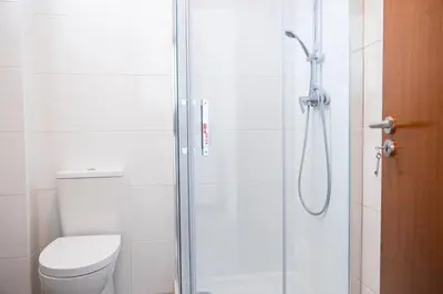 a bathroom with a toilet and a glass shower at Apartamentos Progresso 2º Esq in Funchal