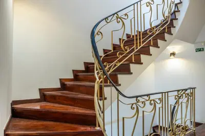 a staircase with wooden treads and a metal railing at Apartamentos Progresso 2º Esq in Funchal