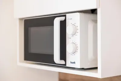 a white microwave oven sitting on a shelf at Apartamentos Progresso 2º Dto in Funchal