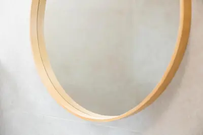 a round mirror with a wooden frame on a wall at Apartamentos Progresso 2º Dto in Funchal