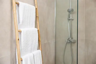 a towel rack in a bathroom with white towels at Apartamentos Progresso 2º Dto in Funchal