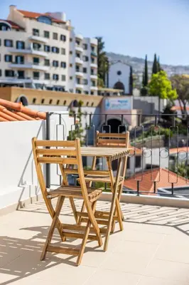 a wooden chair and table on the roof of a building at Apartamentos Progresso 2º Dto in Funchal
