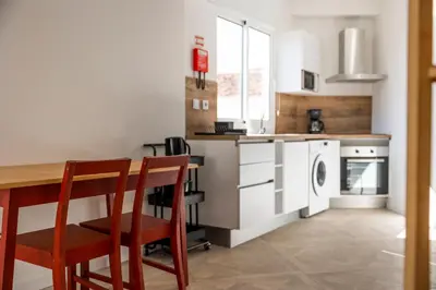 a kitchen with a table and two chairs and a washer and dryer at Apartamentos Progresso 3º Esq in Funchal