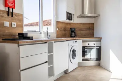 a kitchen with white cabinets and a washer and dryer at Apartamentos Progresso 3º Esq in Funchal