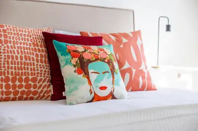 a bed with pillows and a painting of a woman at Apartamentos Progresso 3º Esq in Funchal
