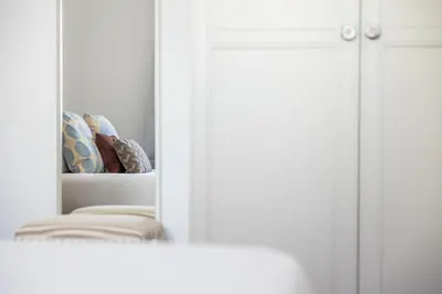 a mirror in front of a white cabinet with pillows at Apartamentos Progresso 3º Dto in Funchal
