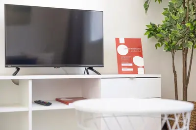 a tv sitting on a white stand with a tv at Apartamentos Progresso 3º Dto in Funchal
