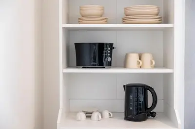 a kitchen shelf with a microwave and a coffee maker at Apartamentos Progresso 3º Dto in Funchal