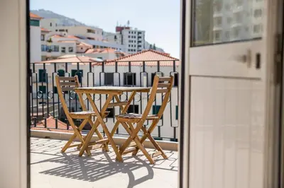 a wooden table and chairs sitting on a balcony at Apartamentos Progresso 3º Dto in Funchal