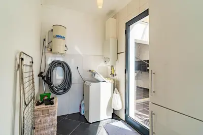 a small kitchen with a refrigerator and a window at Villa Alex,pool and ocean view in Calheta