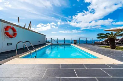 a swimming pool with a view of the ocean at Villa Alex,pool and ocean view in Calheta