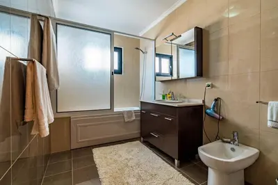 a bathroom with a sink and a toilet and a mirror at Villa Alex,pool and ocean view in Calheta