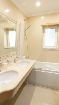 a bathroom with a sink and a tub and a mirror at Apartamento Íris in Lagos