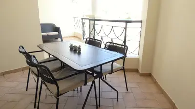 a dining table and chairs in a room with a window at Apartamento Íris in Lagos