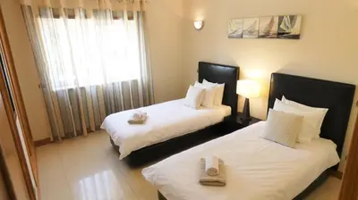 a hotel room with two beds and a window at Apartamento Íris in Lagos