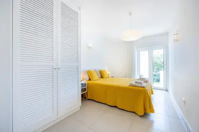 a bedroom with a yellow bed with a yellow blanket at CoolHouses Algarve Luz, 3 Bed townhouse, lovely sea views, village centre, Casa Limoeiro 54LBC in Luz