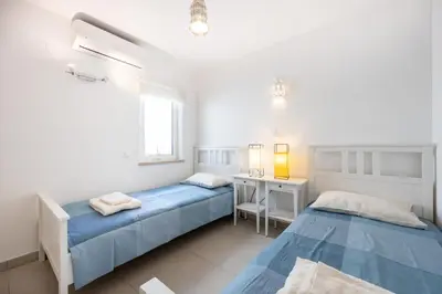 a bedroom with two beds and a desk and a window at CoolHouses Algarve Luz, 3 Bed townhouse, lovely sea views, village centre, Casa Limoeiro 54LBC in Luz
