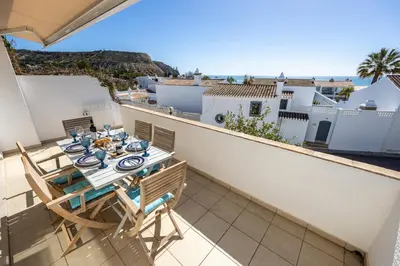 a table and chairs on a balcony with a view of the ocean at CoolHouses Algarve Luz, 3 Bed townhouse, lovely sea views, village centre, Casa Limoeiro 54LBC in Luz