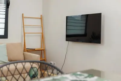 a living room with a flat screen tv on a wall at Quintinha Tropical - Panoramic Gateway to Madeira in Funchal