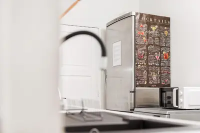 a kitchen with a microwave and a refrigerator at Quintinha Tropical - Panoramic Gateway to Madeira in Funchal