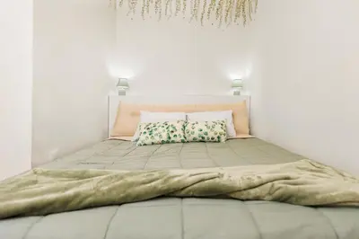 a bed in a white room with two pillows at Quintinha Tropical - Panoramic Gateway to Madeira in Funchal