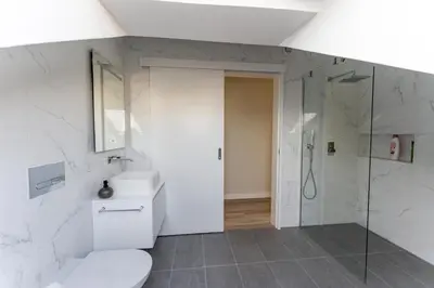 a white bathroom with a toilet and a shower at Penthouse Formosa Sunset and Beach in Funchal