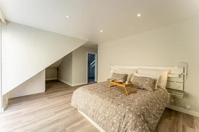 a bedroom with a large bed with a wooden floor at Penthouse Formosa Sunset and Beach in Funchal