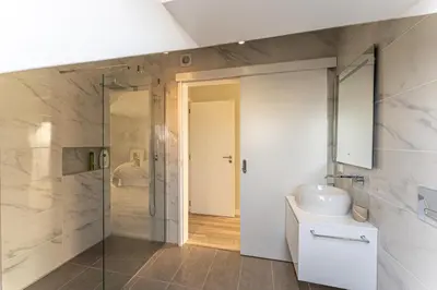 a bathroom with a shower and a sink and a mirror at Penthouse Formosa Sunset and Beach in Funchal