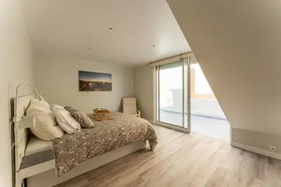 a bedroom with a bed and a large window at Penthouse Formosa Sunset and Beach in Funchal